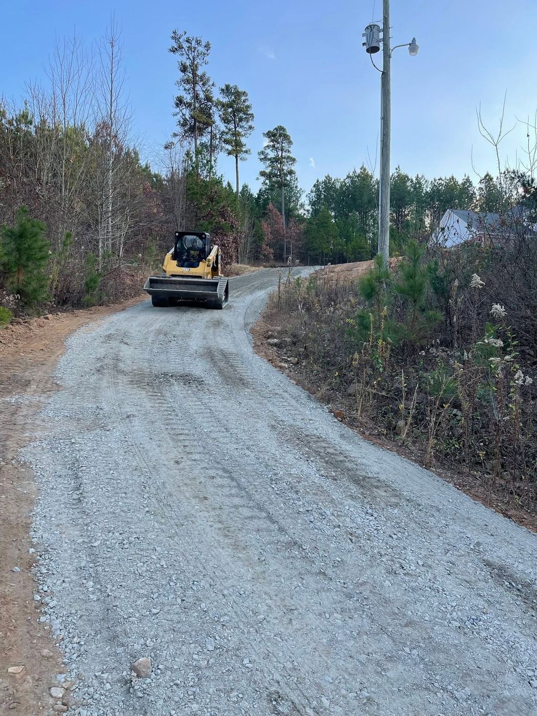 Skid steer grading a driveway